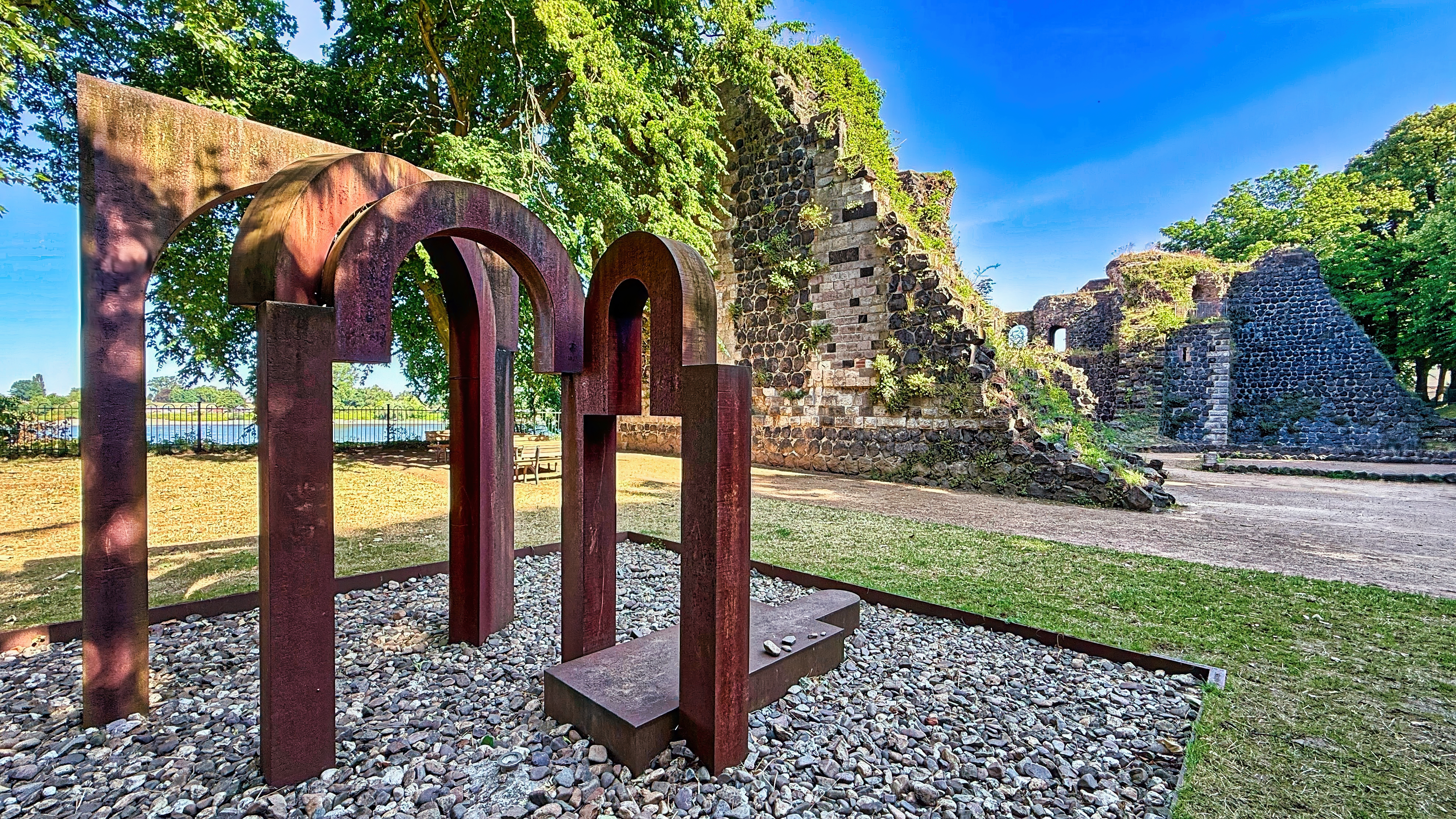 Kaiserpfalz mit Kunstwerk Kaiserpfalz mit Kunstwerk im Vordergrund. Das Kunstwerk besteht aus verschiedenen Metallbögen welche verrostet sind.