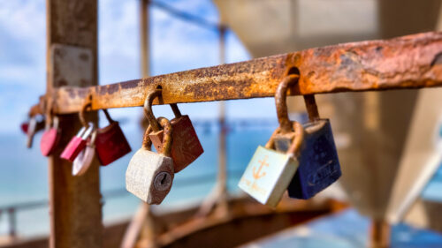 Dänemark (#RF018) Verschieden farbige Liebesschlösser an rostiger Strebe am Leuchtturm Rubjerg Knude Fyr in Dänemark